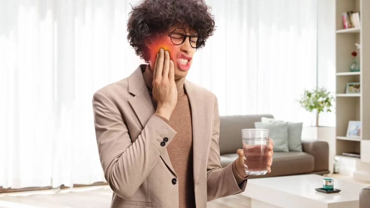 Woman applying a cold compress to her cheek for tooth infection pain